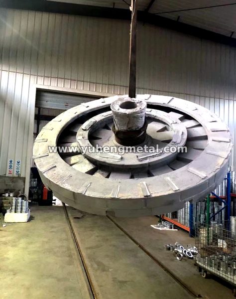 Large aluminum alloy rotor-type casting being lifted in the workshop