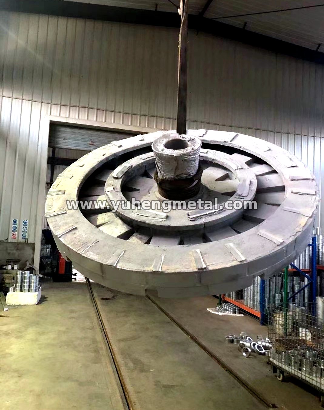 Large aluminum alloy rotor-type casting being lifted in the workshop