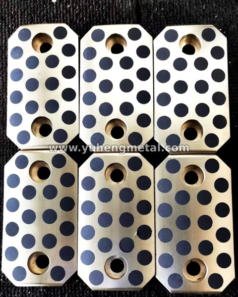 Self-lubricating slide plates with solid lubricant plugs and fixing holes
