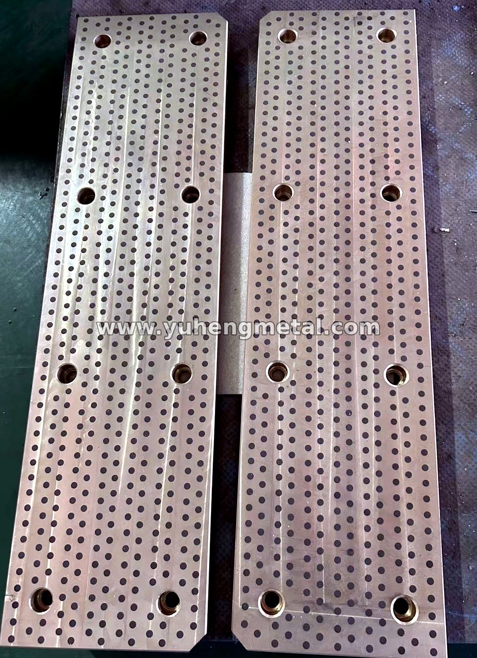 Long self-lubricating slide plates with graphite inserts machined to drawing