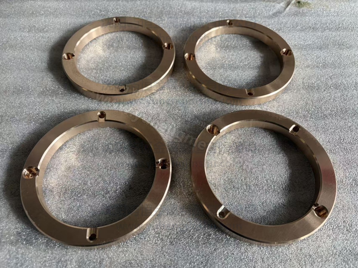 Four machined lead bronze thrust washers with counterbored fixing holes